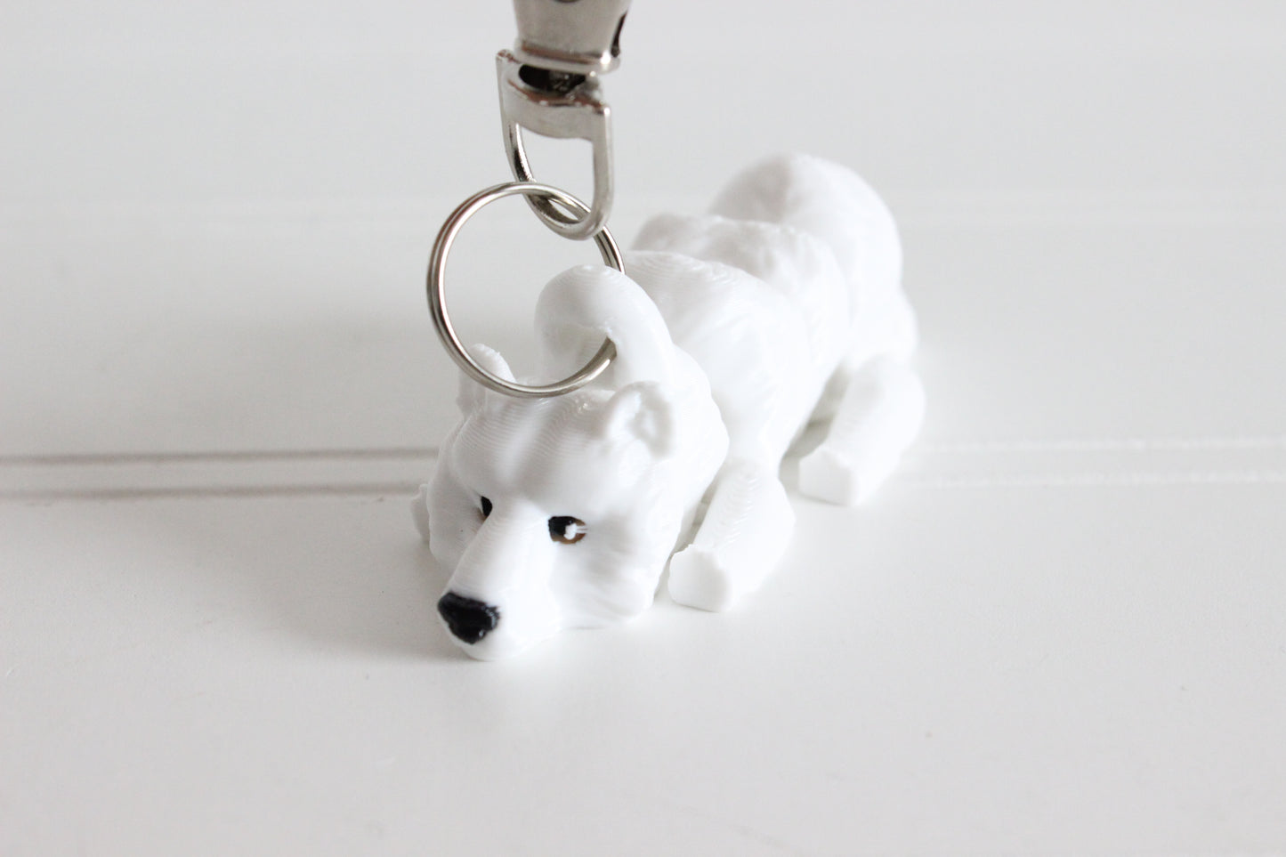 3D-printed white polar bear keychain with a silver swivel quick-clip on a white background.