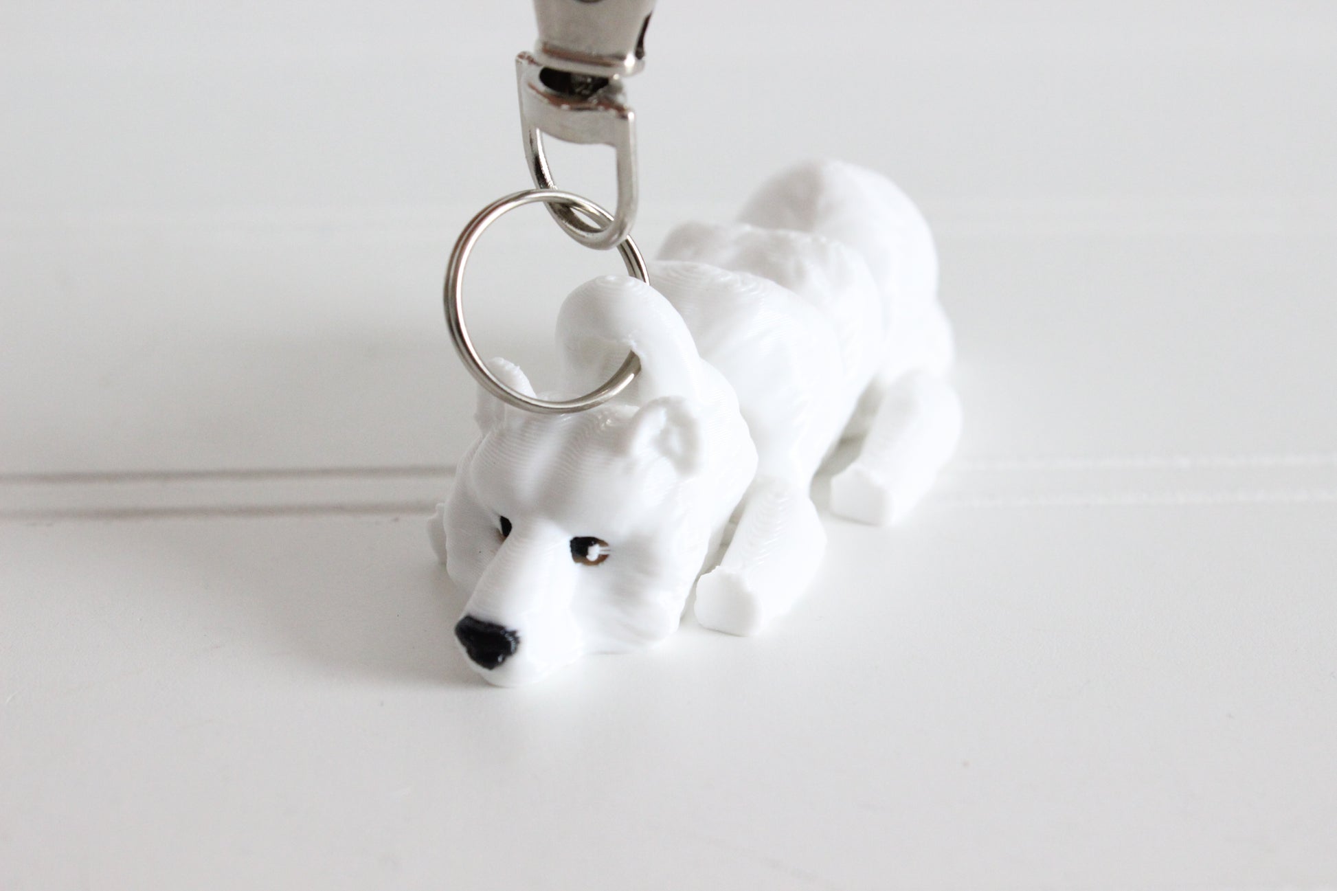 3D-printed white polar bear keychain with a silver swivel quick-clip on a white background.