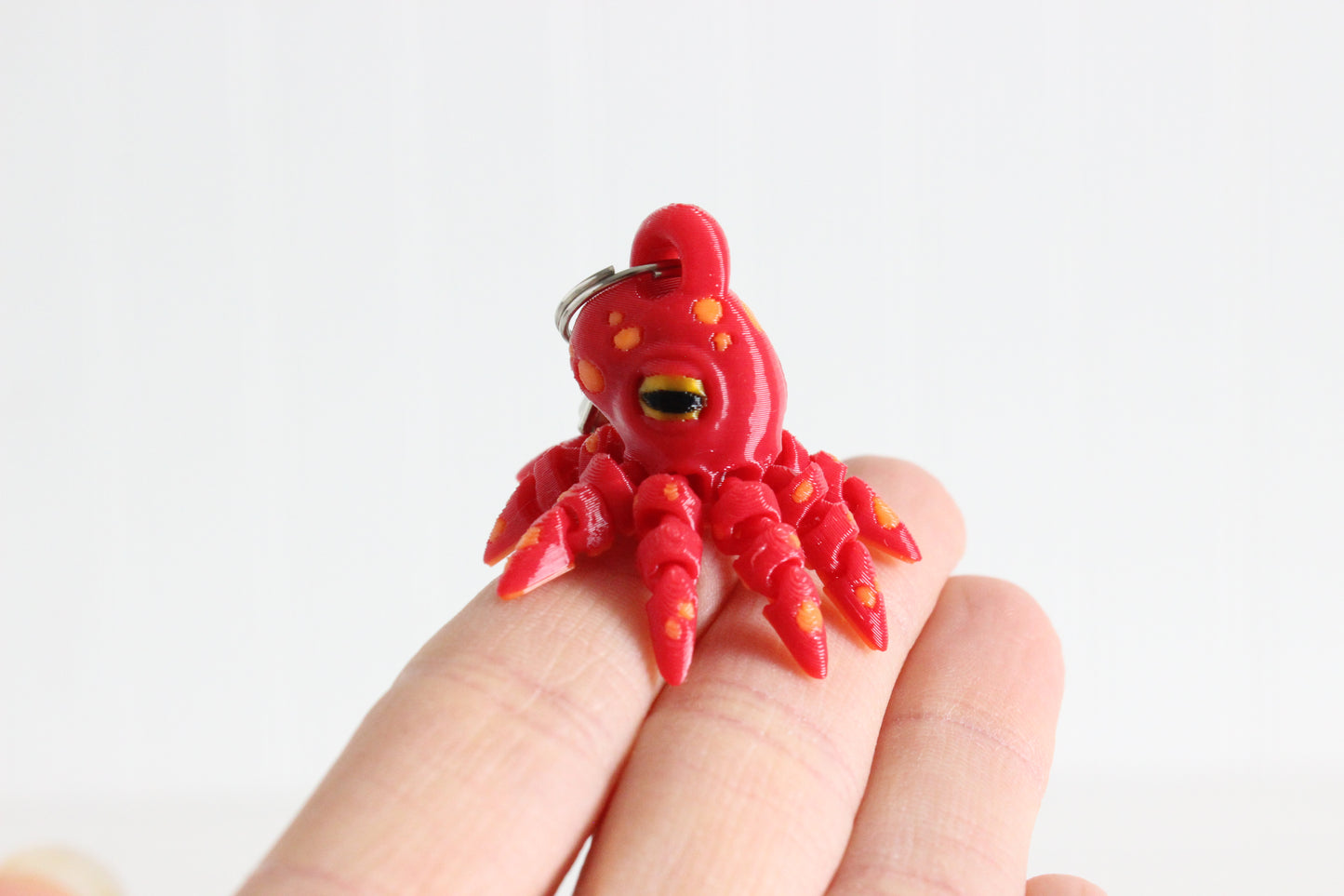 Alternate view of the 3D-printed octopus with curled tentacles keychain showing its sculpted details and segmented design.