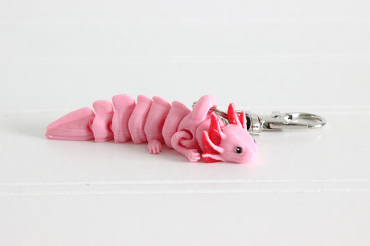 Side view of a pink 3D-printed axolotl keychain on a white background.