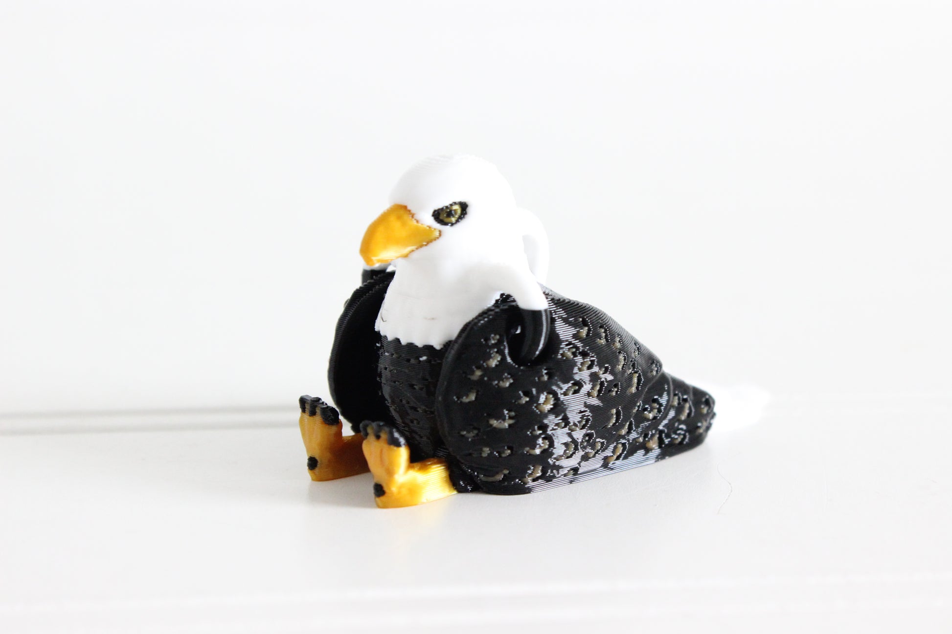 3D-printed brown-and-white eagle keychain showing its sculpted details and segmented design.