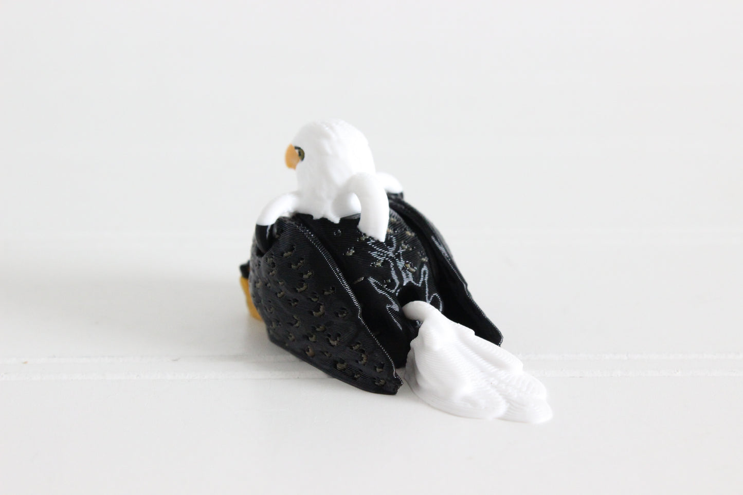 Alternate view of the 3D-printed brown-and-white eagle keychain showing its sculpted details and segmented design.