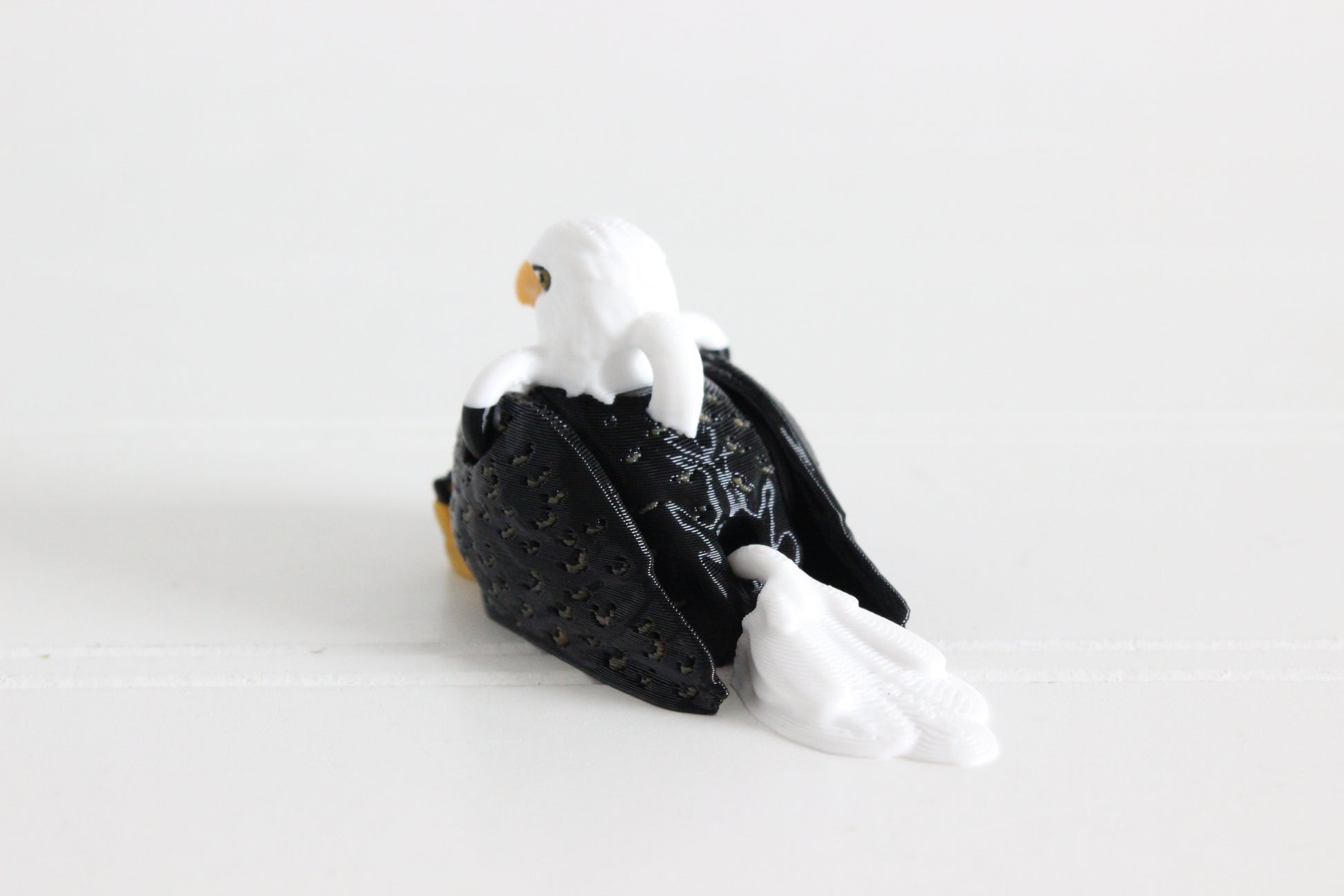 Alternate view of the 3D-printed brown-and-white eagle keychain showing its sculpted details and segmented design.