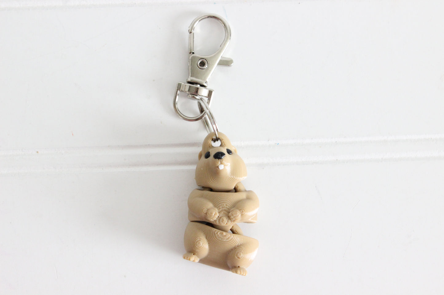3D-printed brown groundhog keychain with a silver swivel quick-clip on a white background.