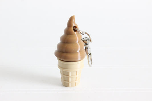 3D-printed chocolate soft-serve ice cream cone keychain with a metal key ring on a white background.