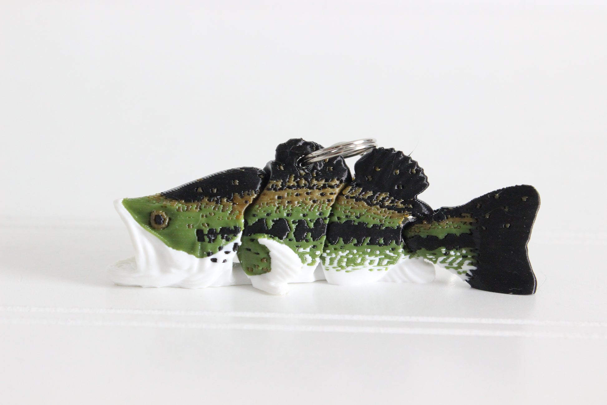3D-printed green largemouth bass keychain with a silver swivel quick-clip on a white background.