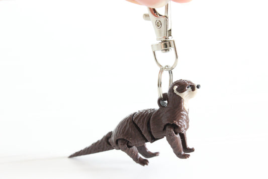 3D-printed brown river otter keychain with a silver swivel quick-clip on a white background.