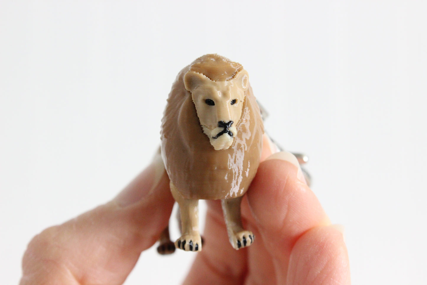 3D-printed golden lion keychain with a silver swivel quick-clip on a white background.