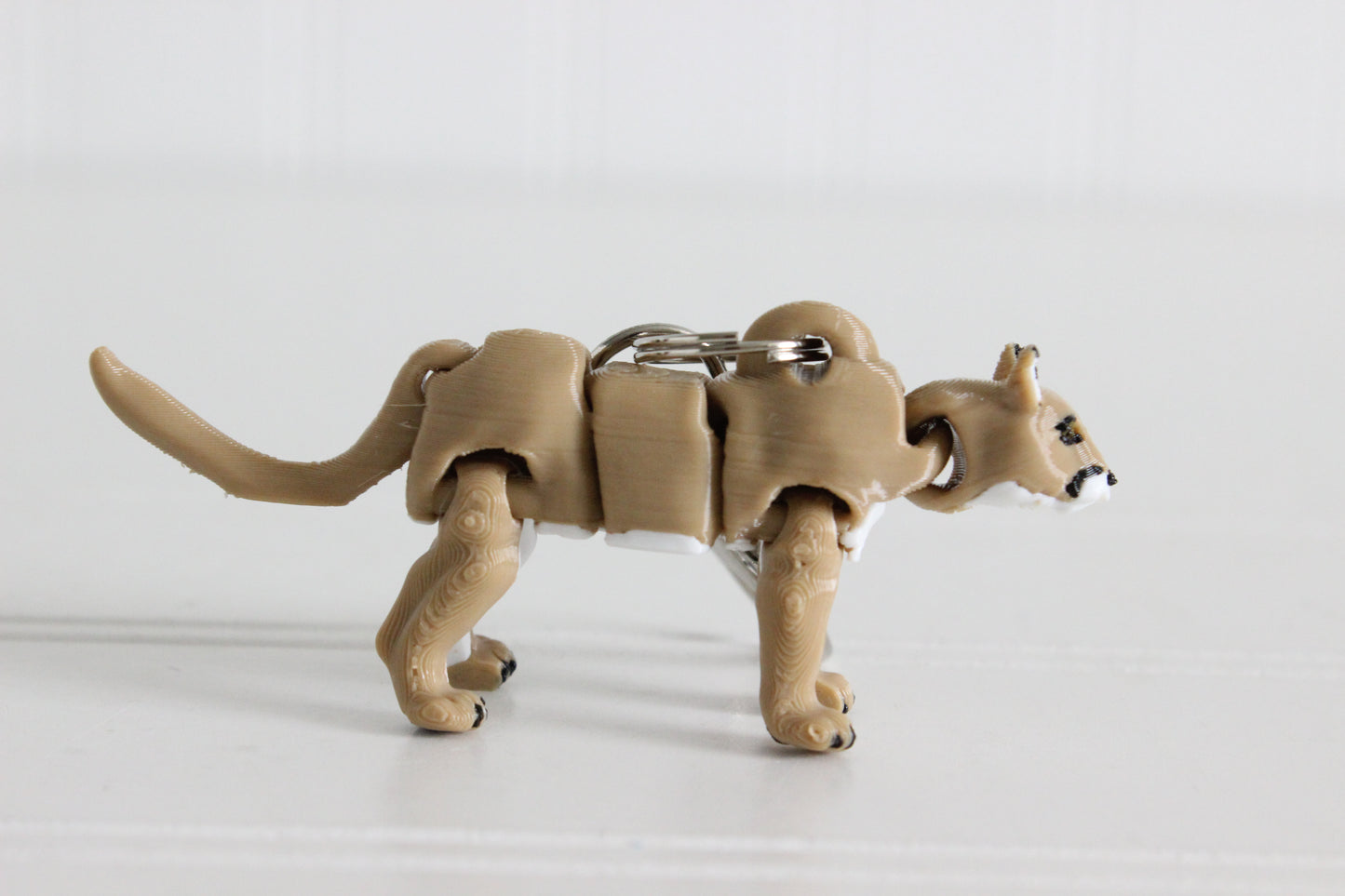 Side view of the articulated cougar keychain showing flexible joints and long tail.