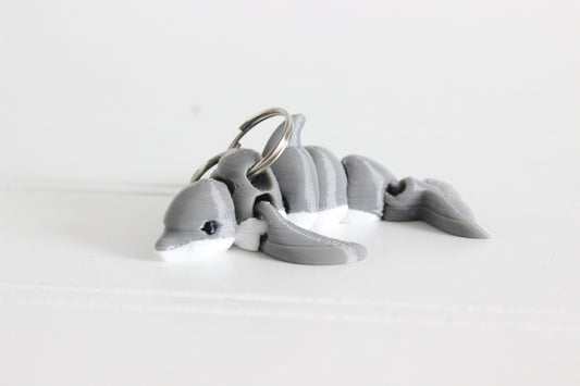 3D-printed gray dolphin keychain with a silver swivel quick-clip on a white background.