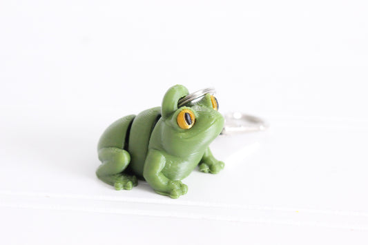 3D-printed green frog keychain with a silver swivel quick-clip on a white background.