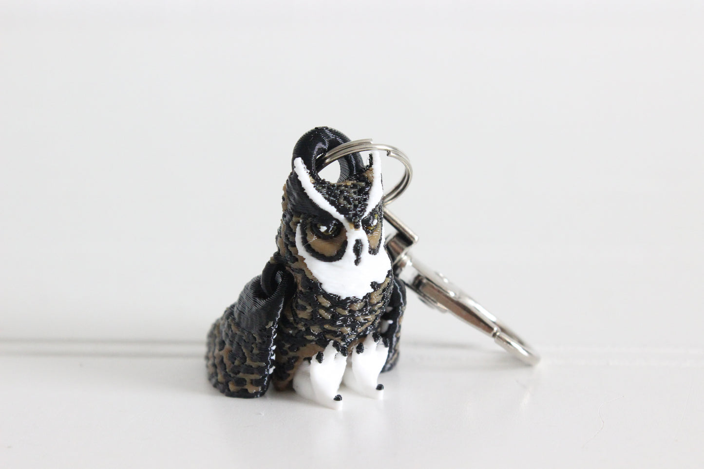 3D-printed brown great horned owl keychain with a silver swivel quick-clip on a white background.