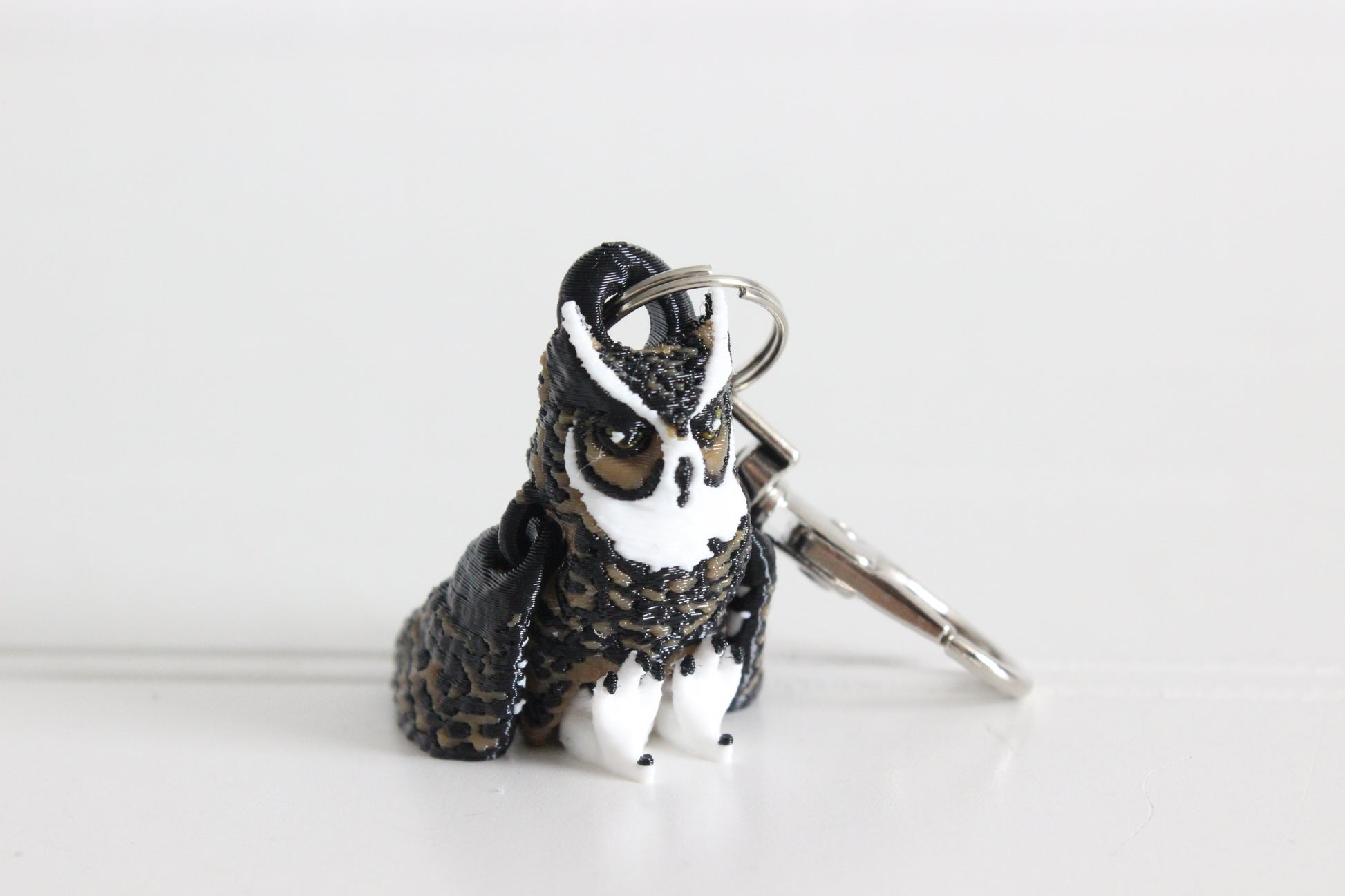 3D-printed brown great horned owl keychain with a silver swivel quick-clip on a white background.
