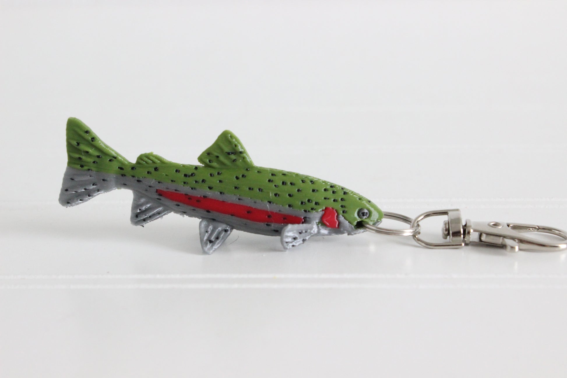3D-printed rainbow trout with a red side stripe keychain with a silver swivel quick-clip on a white background.