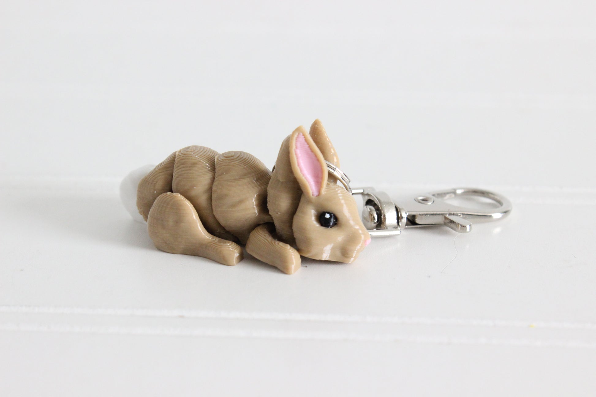 3D-printed brown rabbit keychain with a silver swivel quick-clip on a white background.