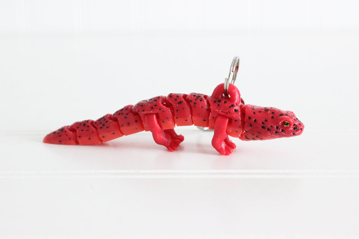 3D-printed red salamander keychain with a silver swivel quick-clip on a white background.