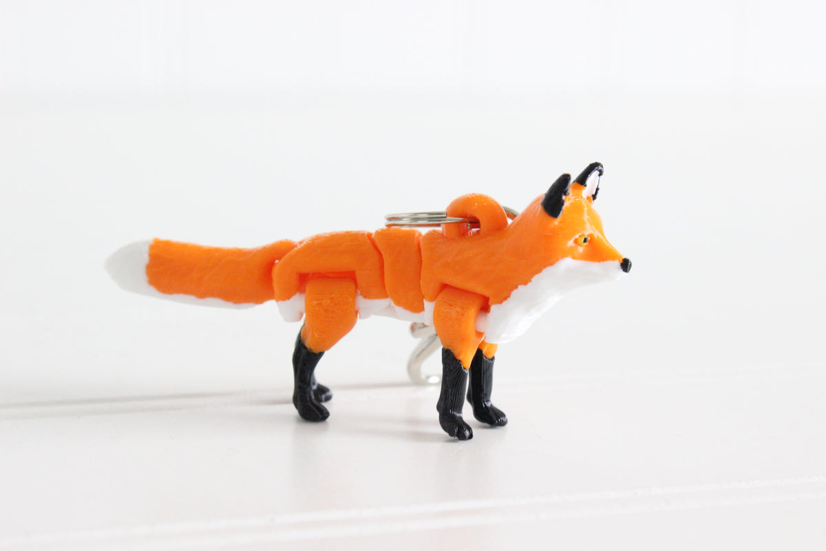 3D-printed orange-red fox keychain with a silver swivel quick-clip on a white background.