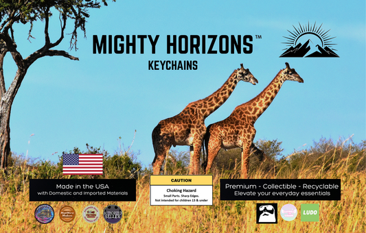 Mighty Horizons Keychains zoo retail display sign with two giraffes in a savanna, U.S.-made materials statement, choking-hazard warning for ages 13 and under, premium collectible recyclable message, and designer attribution logos.